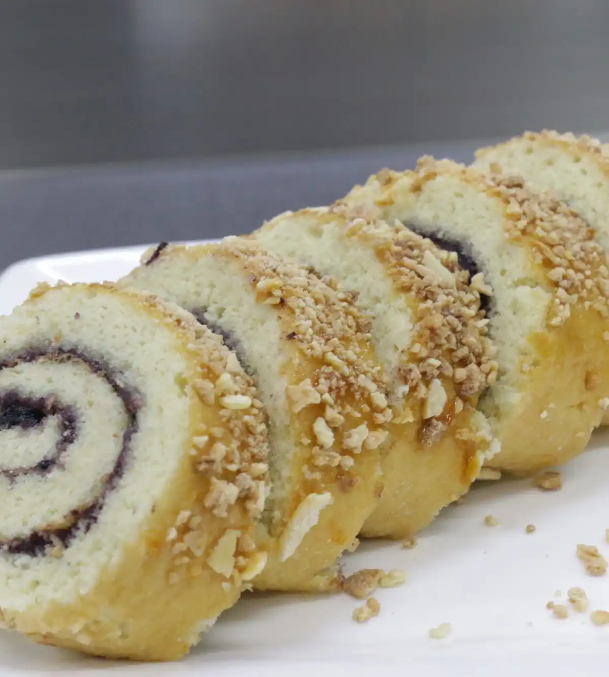 Slices of a jam-filled sponge roll topped with chopped nuts