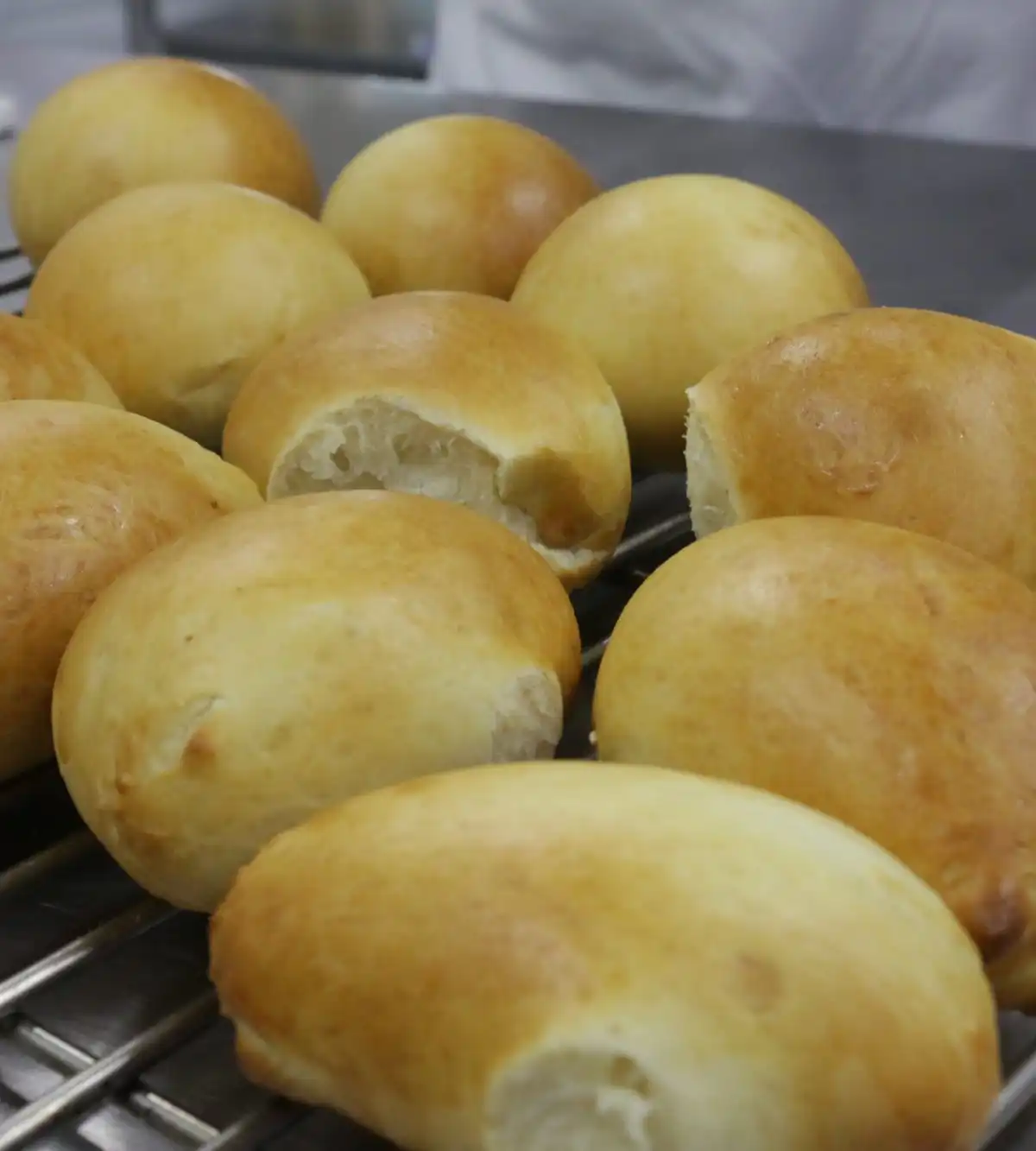 Soft golden milk buns cooling on a wire rack
