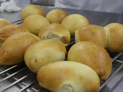 Soft golden milk buns cooling on a wire rack