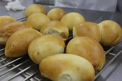 Soft golden milk buns cooling on a wire rack