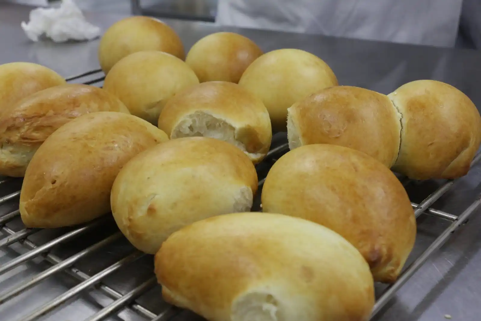 Soft golden milk buns cooling on a wire rack