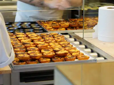 Trays of custard tarts fresh from the oven on a bakery counter