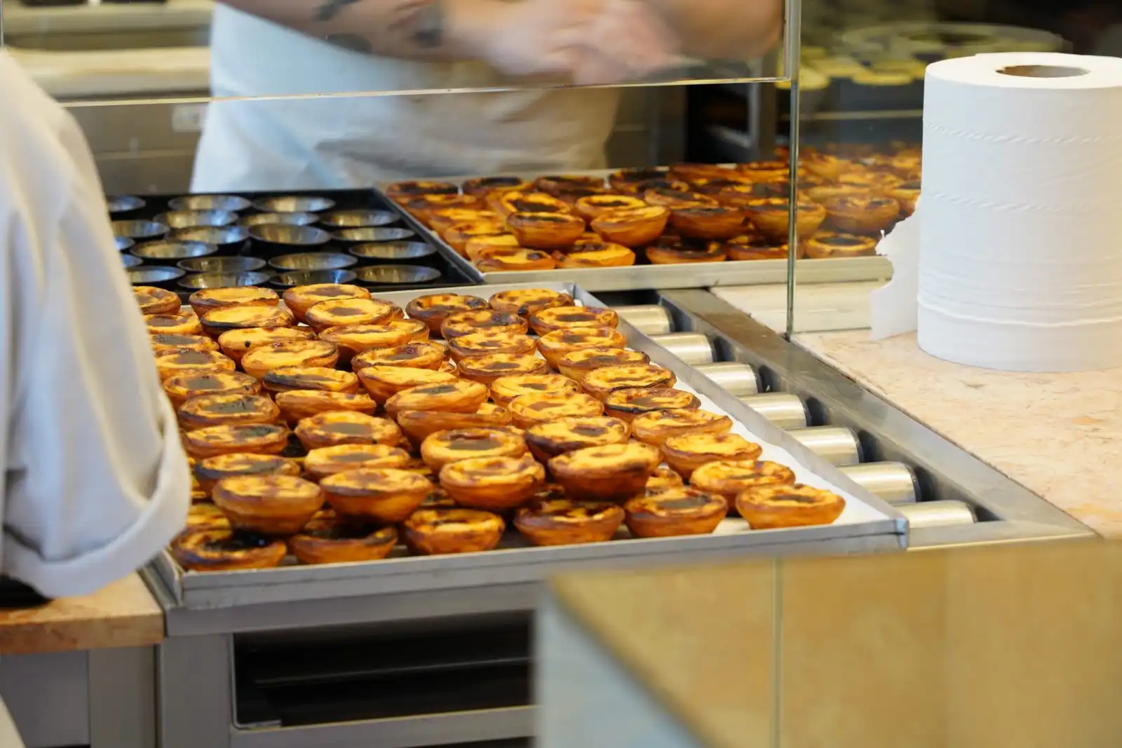 Trays of custard tarts fresh from the oven on a bakery counter
